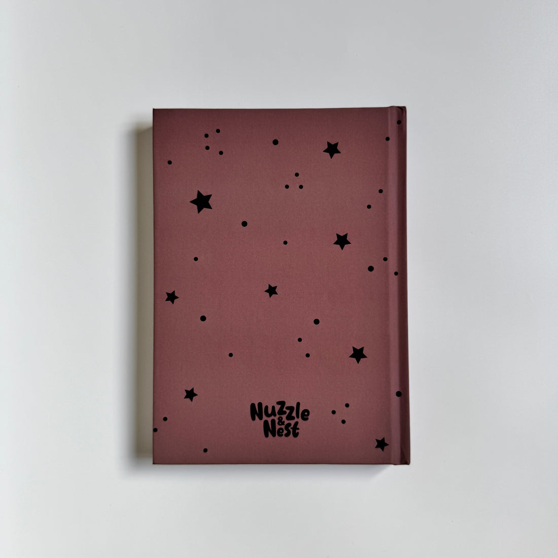 Maroon notebook with black star patterns on a light gray background