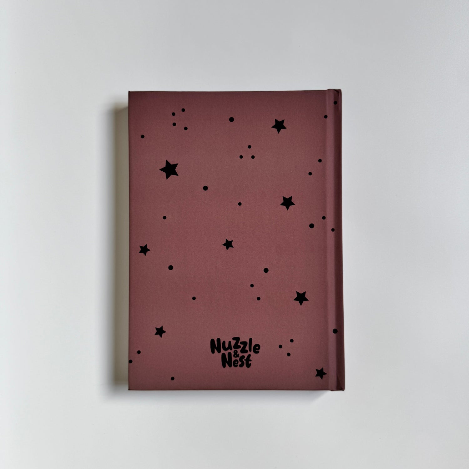 Maroon notebook with black star patterns on a light gray background
